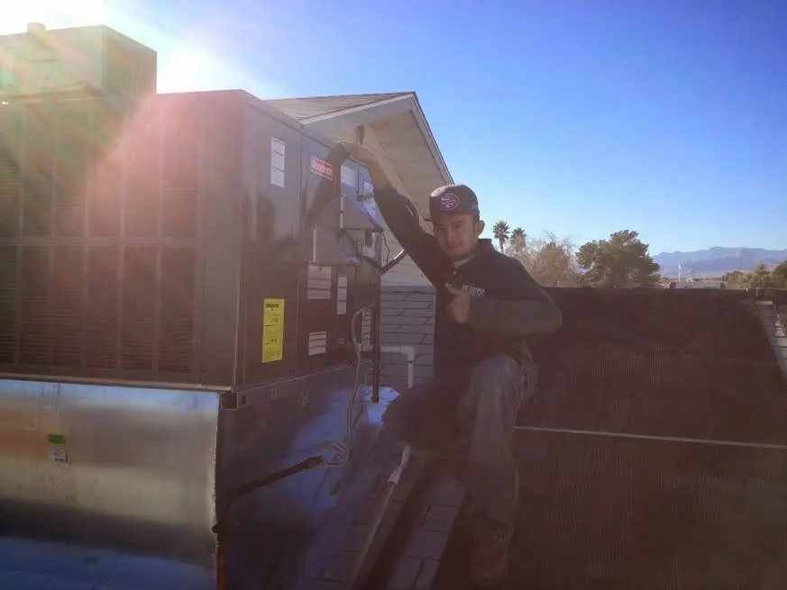 HVAC technician performing Air Duct Cleaning on a rooftop unit in Fleming Island
